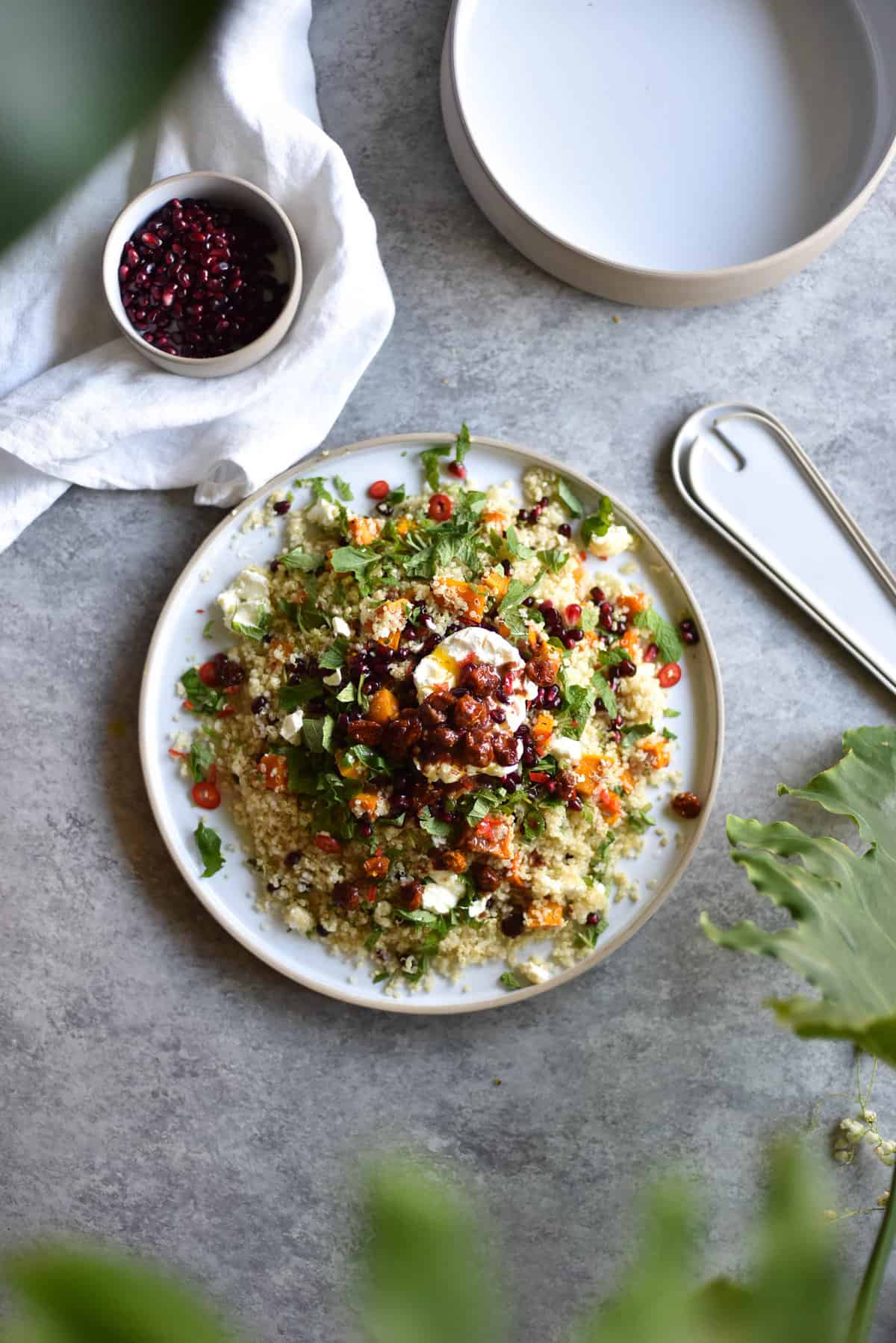 quinoa salad with roasted vegetables, lemon butter and inca berries on a light backdrop with foliage bokeh