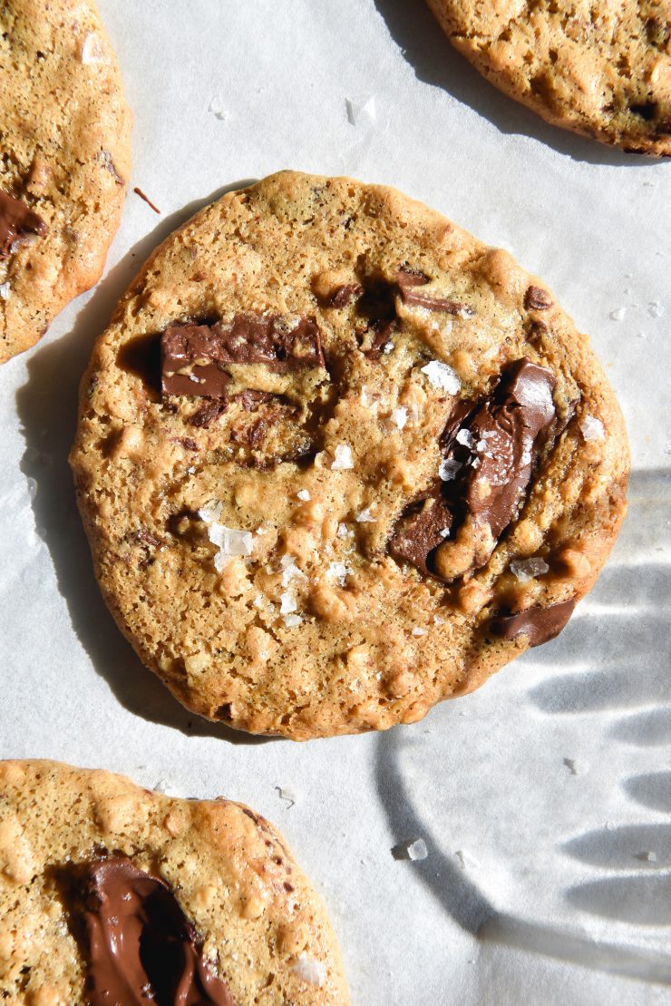 An aerial image of gluten free peanut butter cookies on a baking sheet in bright sunlight.