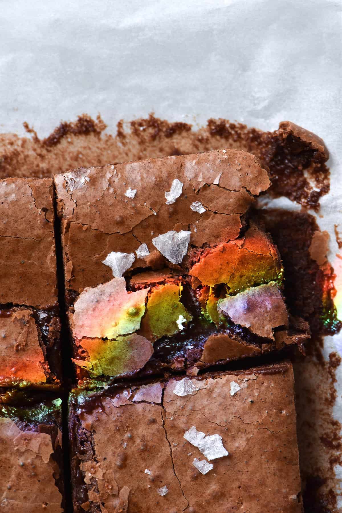 Gluten free, grain free fudgy brownies with a crackly top, sea salt flakes and a sunshine created rainbow on the top