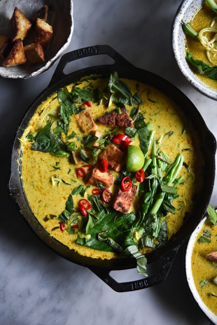 FODMAP friendly vegan Laksa with zucchini noodles and salt and pepper tofu puffs from www.georgeats.com. Delicious, simple, and also grain free and nut free. Laksa for everyone!