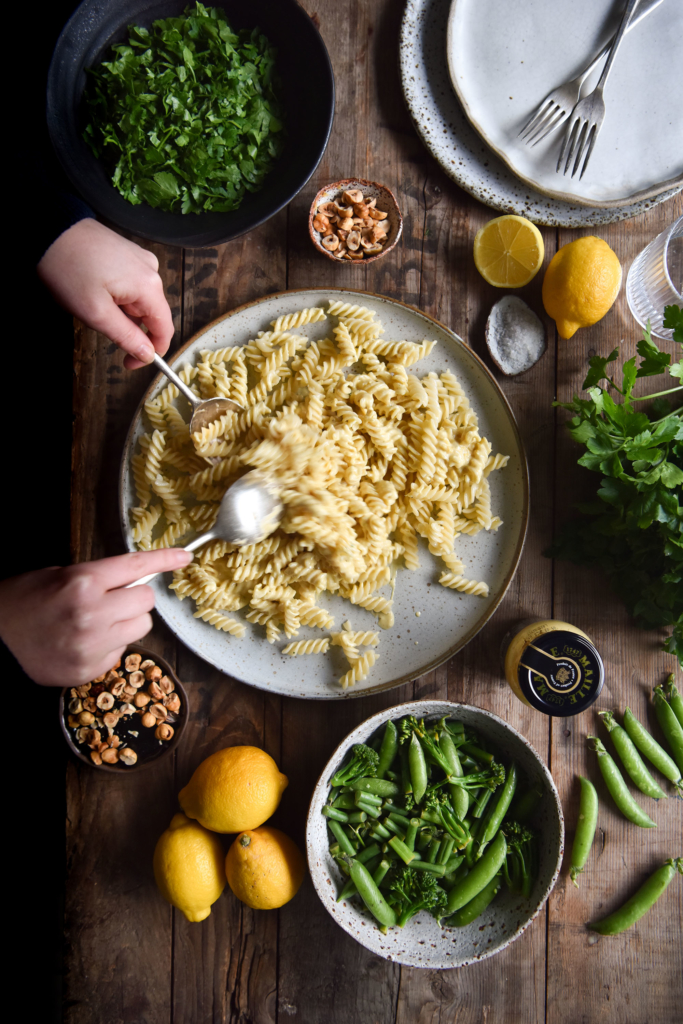 Creamy lemon and mustard pasta with spring vegetables, herbs and toasted hazelnuts. Gluten free, FODMAP friendly, vegetarian and ready in 20 minutes. Recipe from www.georgeats.com @georgeats