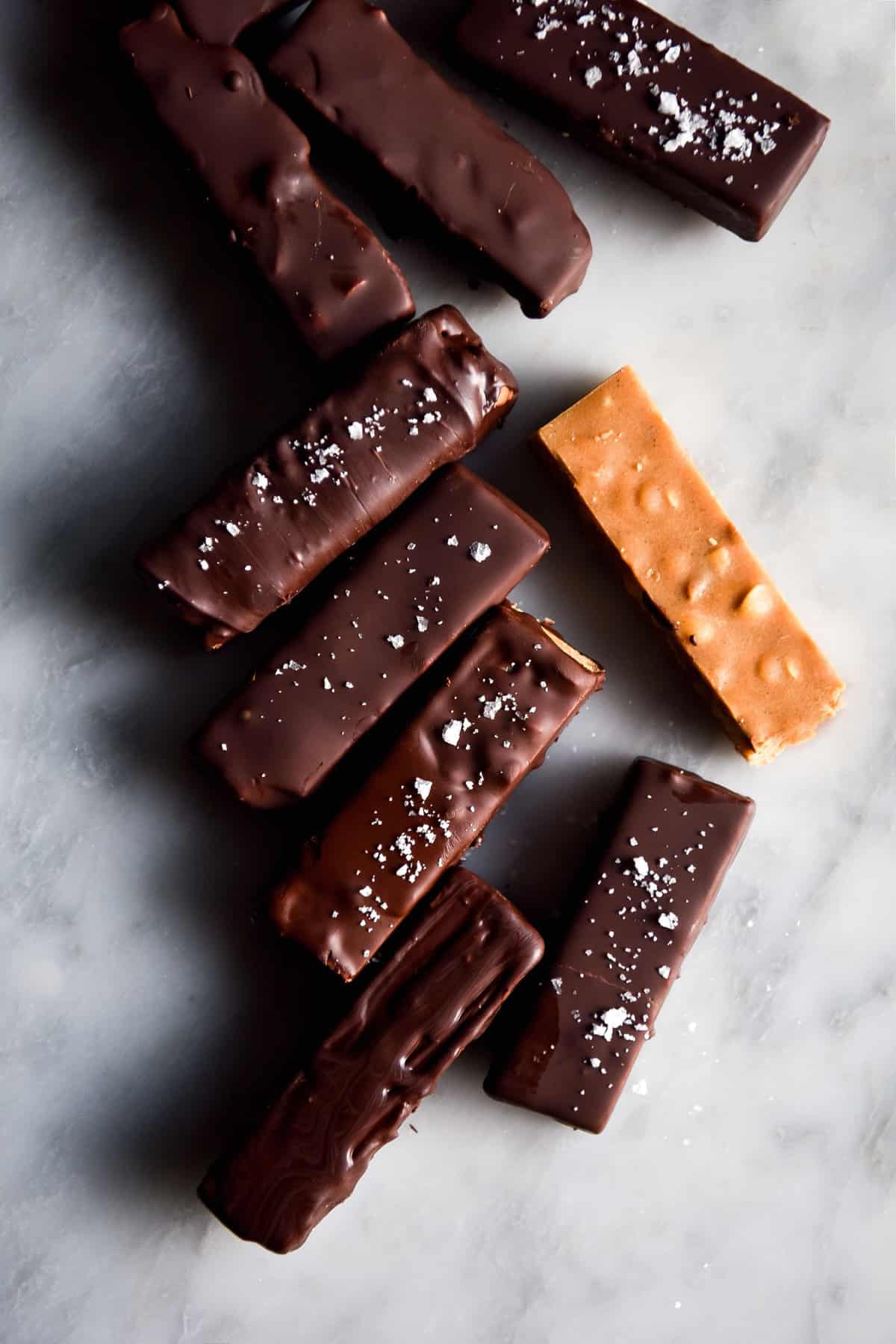 Chewy vegan peanut and chocolate bars on a white marble table