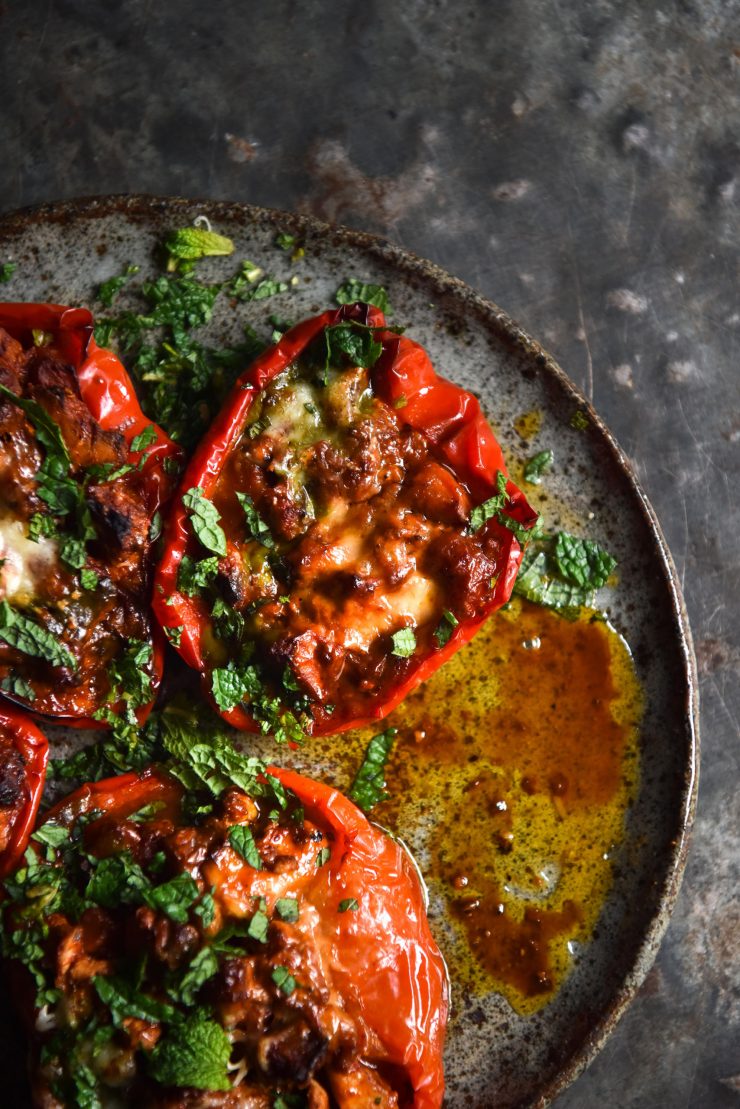 An aerial image of vegetarian mince stuffed capsicums on a dark blue ceramic plate atop a dark blue steel backdrop