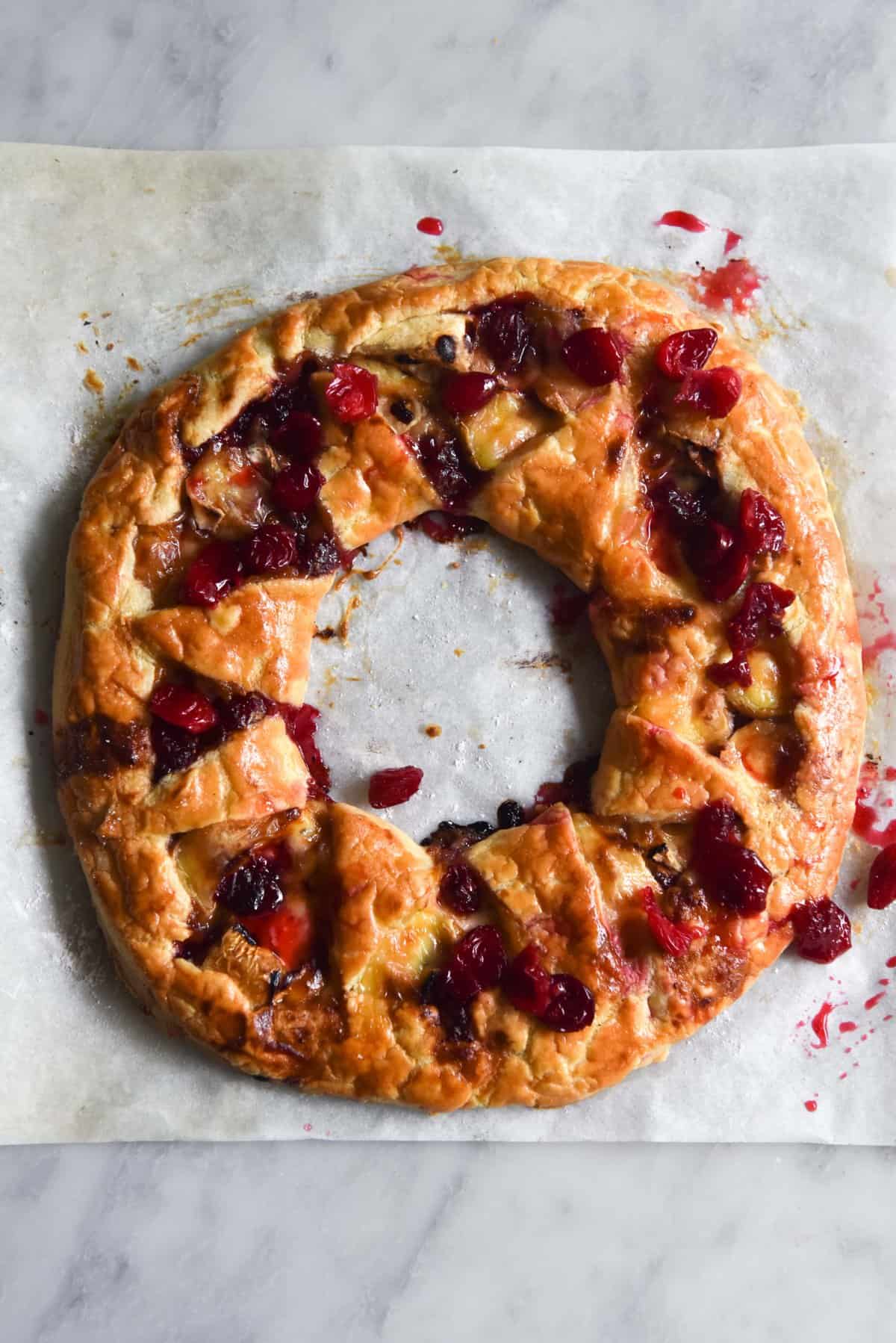 An aerial image of a gluten free brie cranberry wreath on a piece of baking paper 