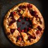 An aerial image of a gluten free brie cranberry wreath on a dark steel backdrop