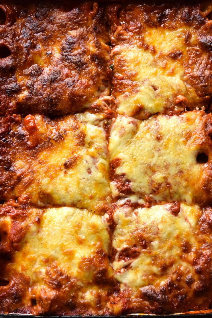 An aerial close up image of a tray of gluten free pasta bake with a cheesy, golden brown topping