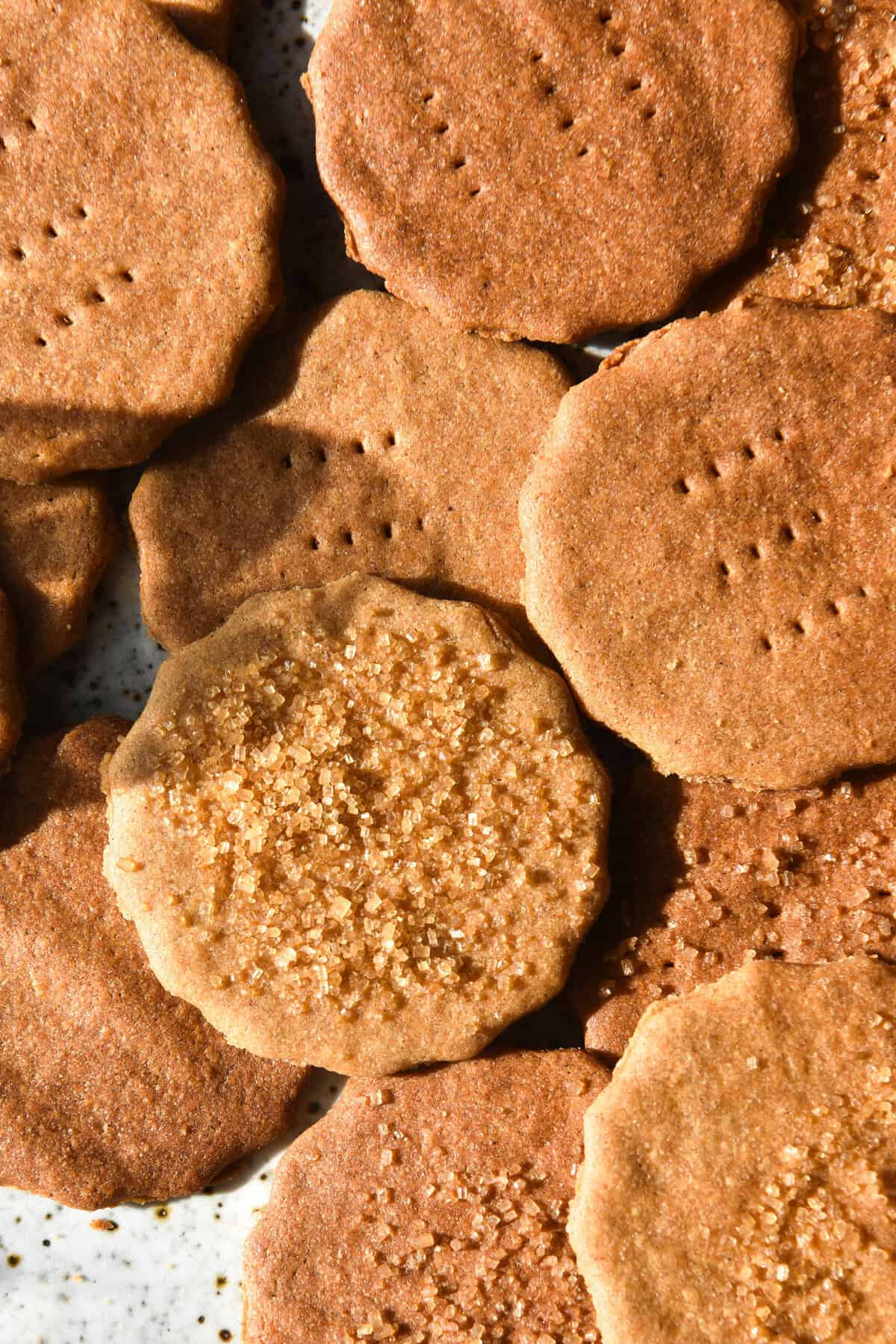 An aerial sunlit close up view of a plate of gluten free graham crackers topped with finishing sugar