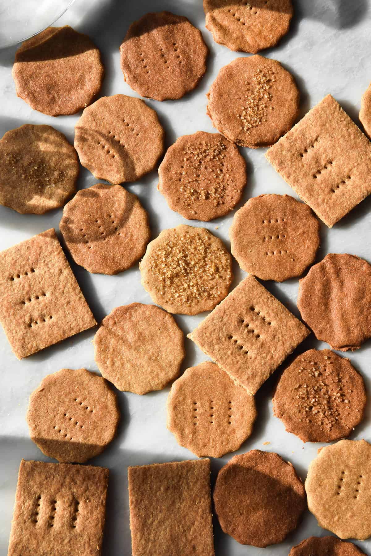 An aerial view of gluten free Graham crackers on a sunlit white marble table