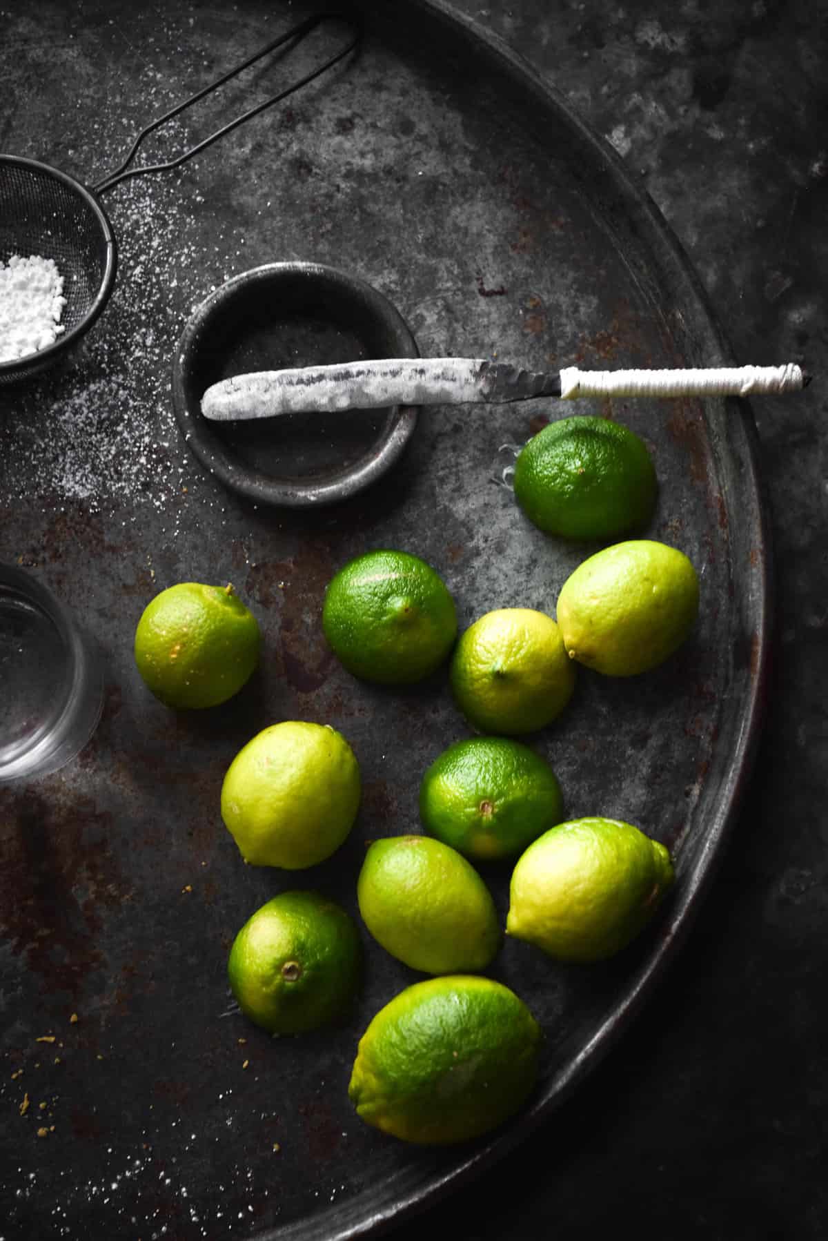 A moody aerial image of limes on a dark blue steel backdrop.