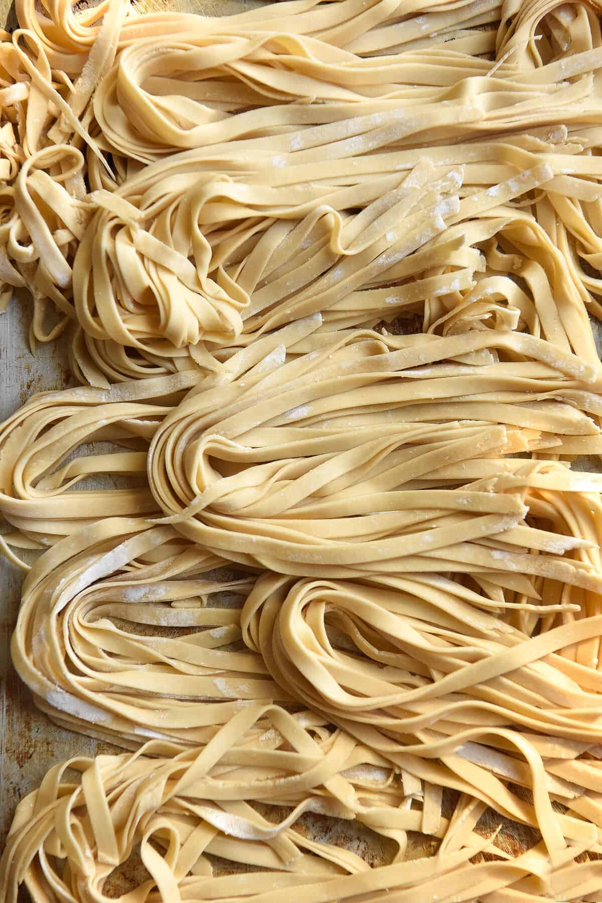 An aerial close up image of gluten free egg pasta on a steel backdrop