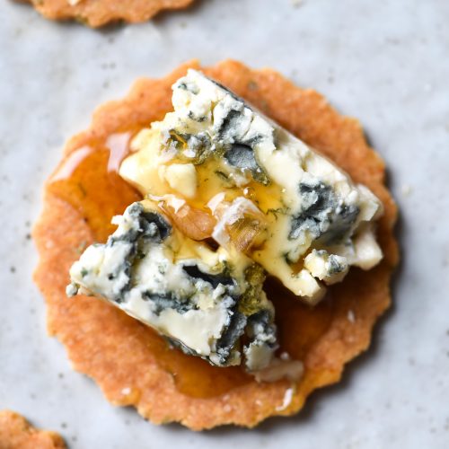 Paleo, gluten free almond crackers topped with blue cheese and a drizzle of honey