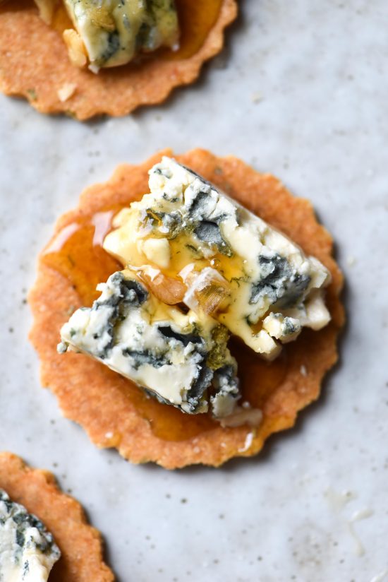 Paleo, gluten free almond crackers topped with blue cheese and a drizzle of honey