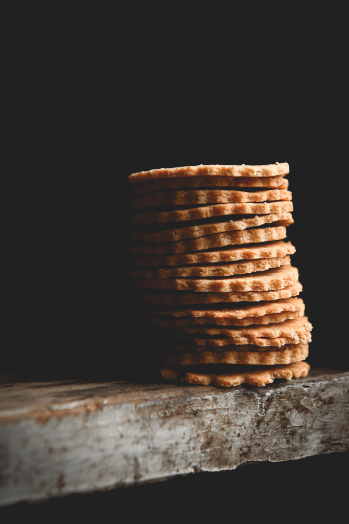 A stack of grain free almond crackers against a black backdrop