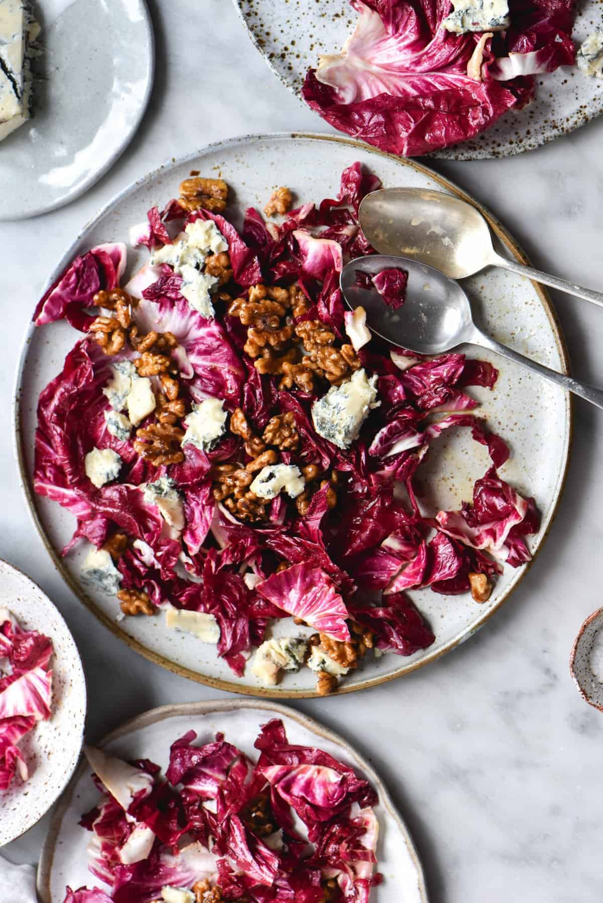 Radicchio salad with blue cheese, honey cinnamon walnuts and a low FODMAP salad dressing on a white marble backdrop