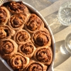 An aerial view of gluten free sourdough vegemite scrolls in harsh sunlight. Water glasses sit to the right of the image and create filtered light