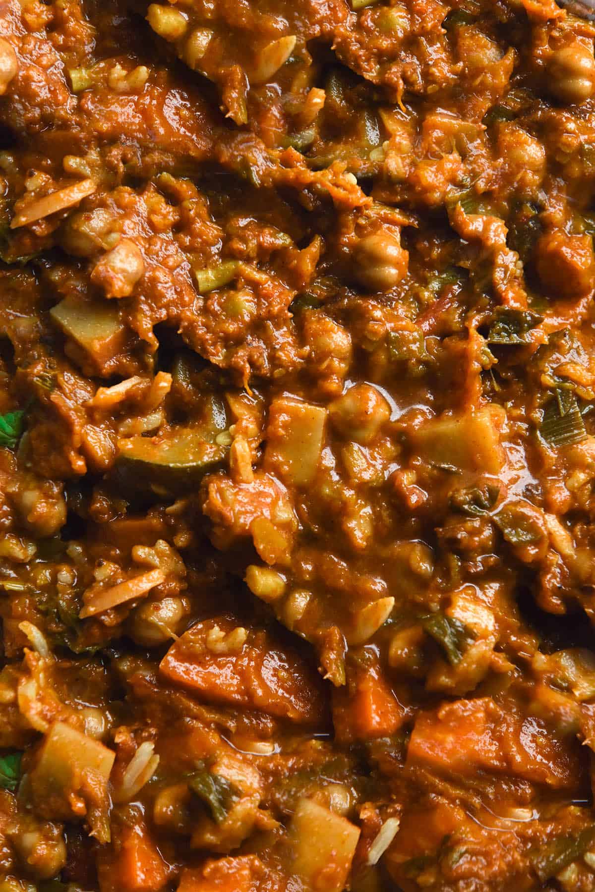 A close up macro image of FODMAP friendly vegetable tagine, filled with vegetables, chickpeas and slivered almonds 