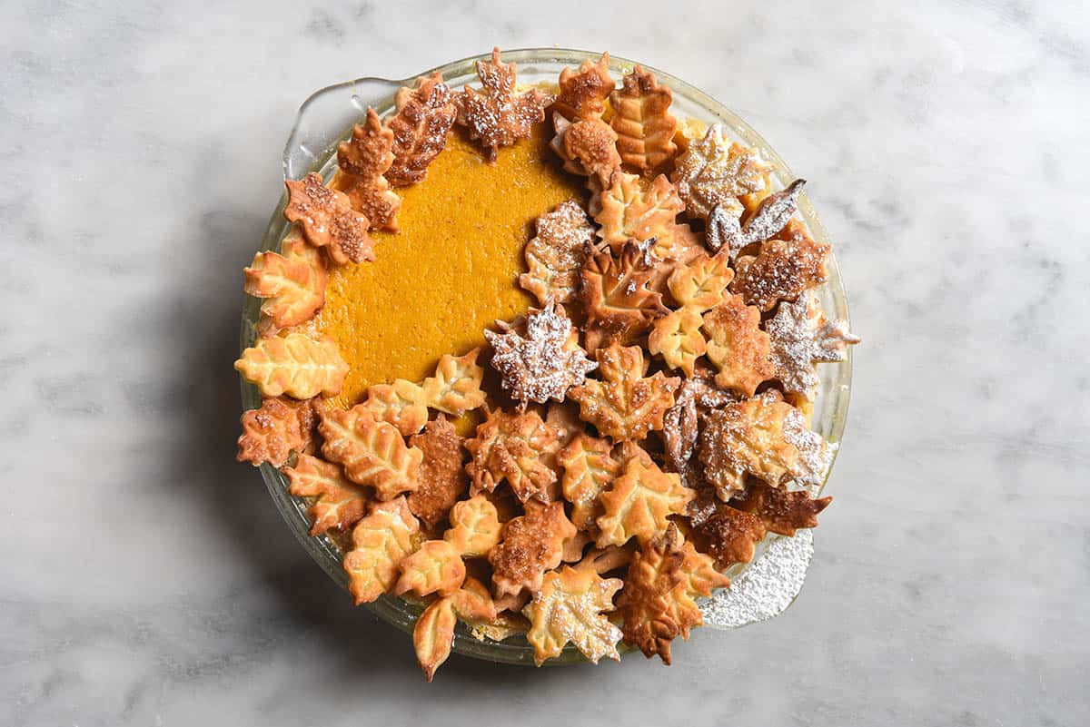 An aerial view of a gluten free pumpkin pie topped with pastry leaves 