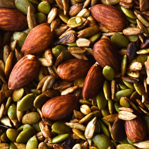 A close up macro image of a gluten free nut mix with pepitas, sunflower seeds and almonds cooked in Tamari