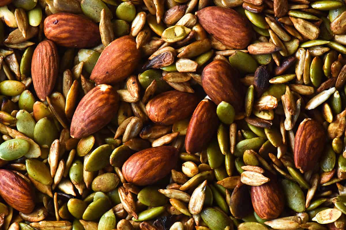 A close up macro image of a gluten free nut mix with pepitas, sunflower seeds and almonds cooked in Tamari