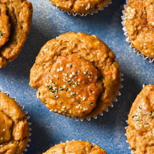 An aerial image of gluten free banana carrot muffins on a bright blue ceramic plate