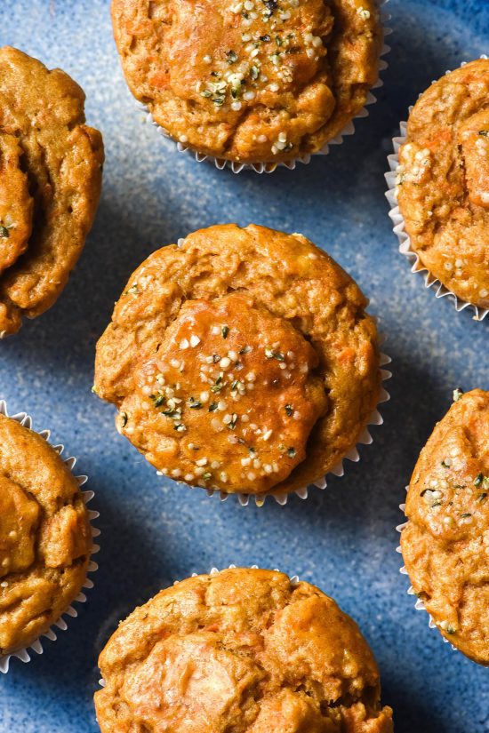 An aerial image of gluten free banana carrot muffins on a bright blue ceramic plate