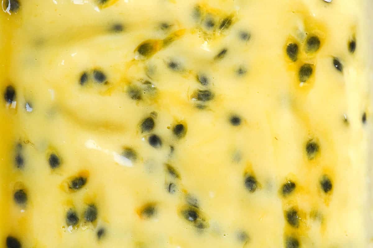 An aerial macro image of passionfruit curd 