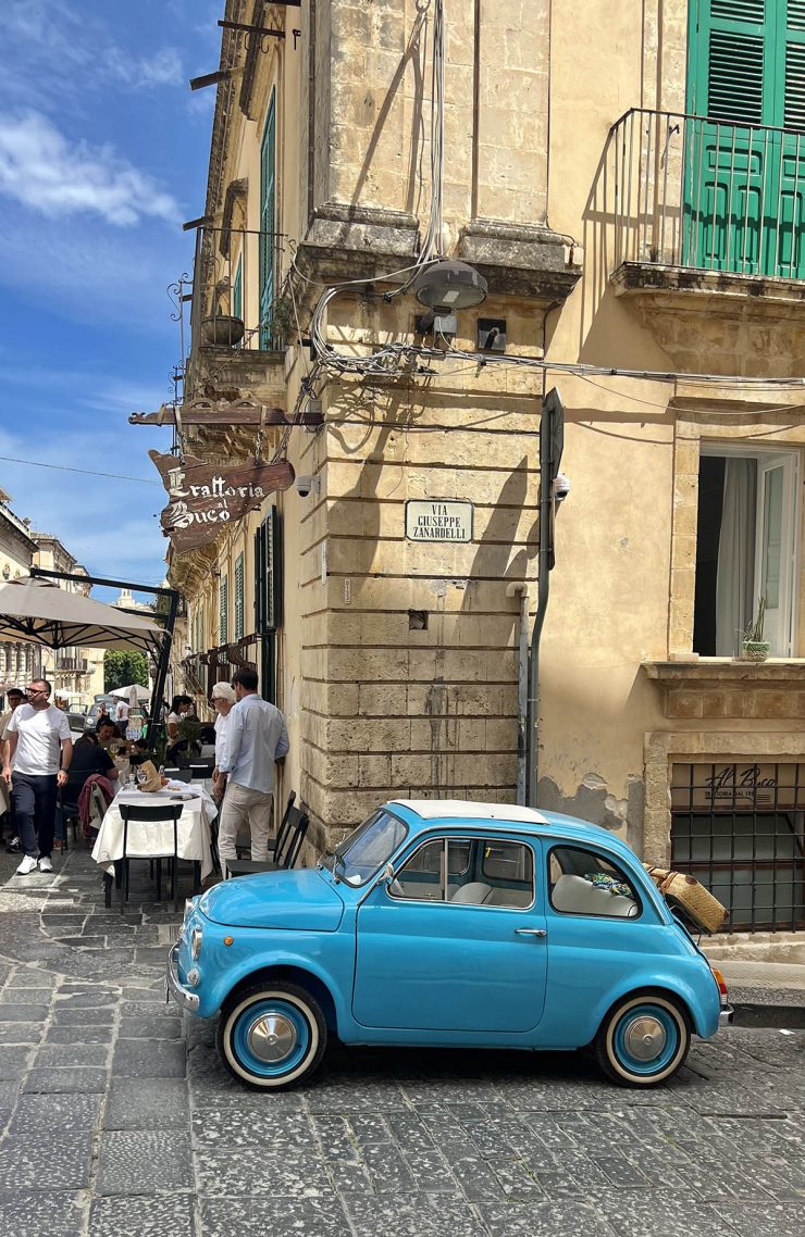 An image of an old blue Italian car on a street in Noto, Sicily.