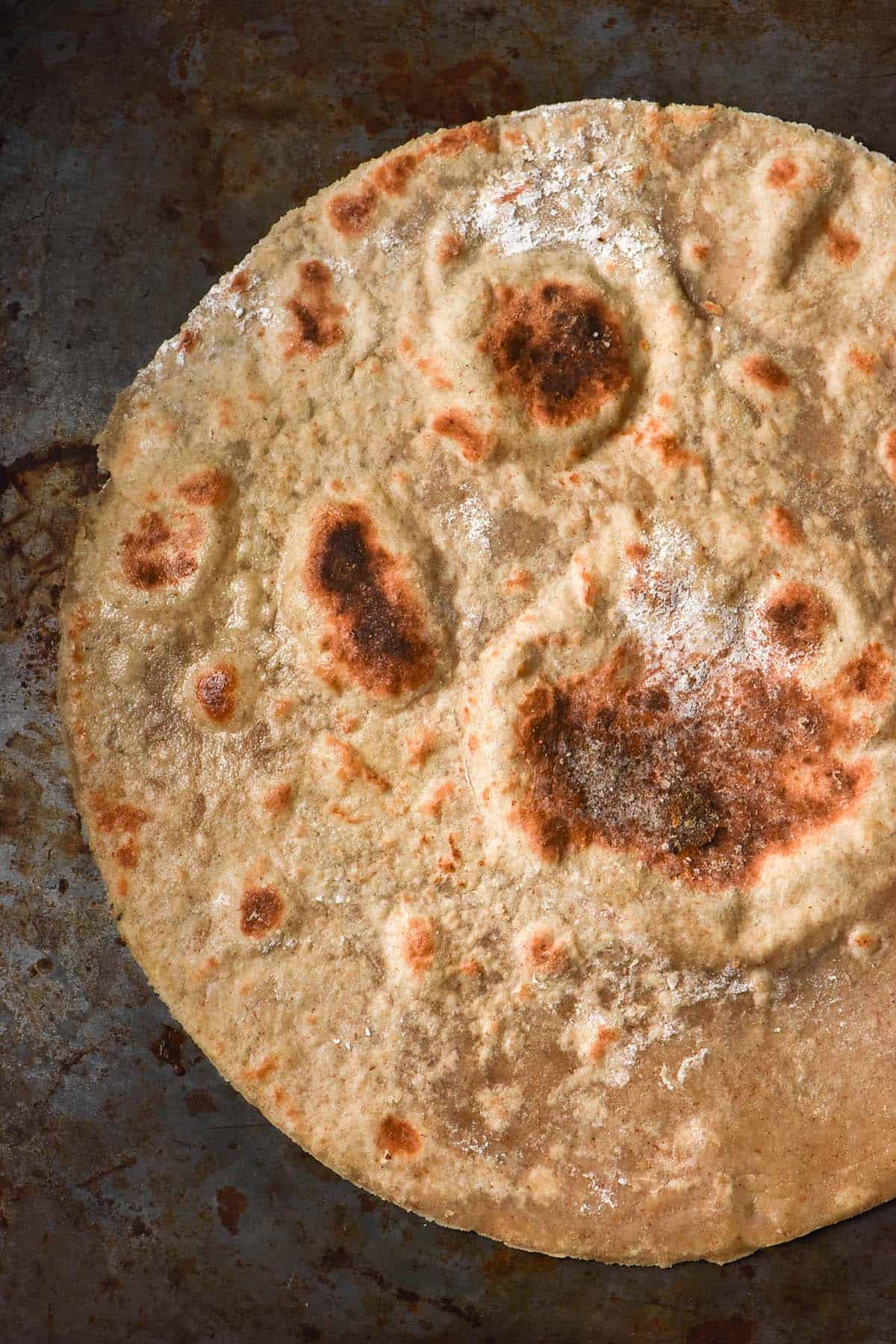 An aerial image of a golden brown buckwheat wrap atop a dark steel backdrop