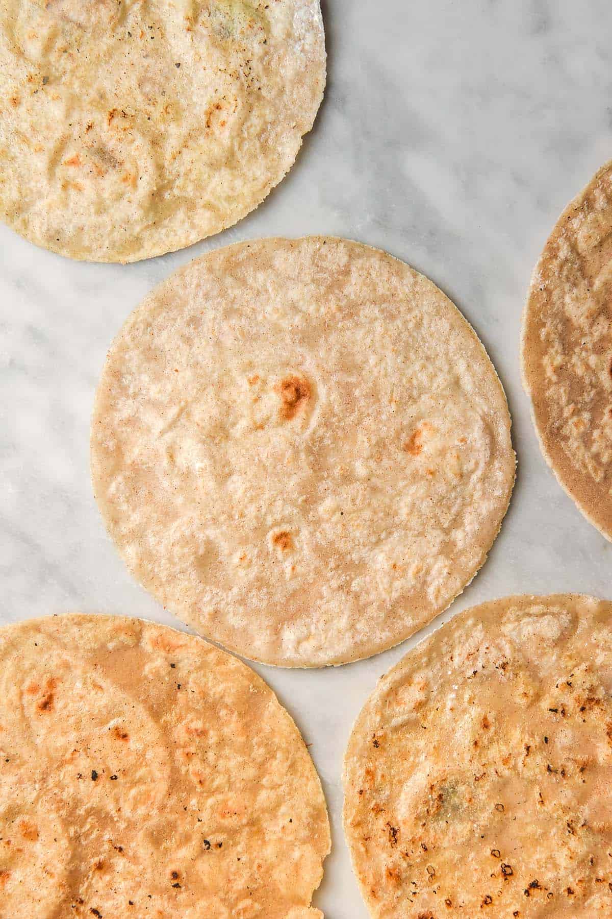 An aerial image of a group of gluten free wraps arranged on a white marble table