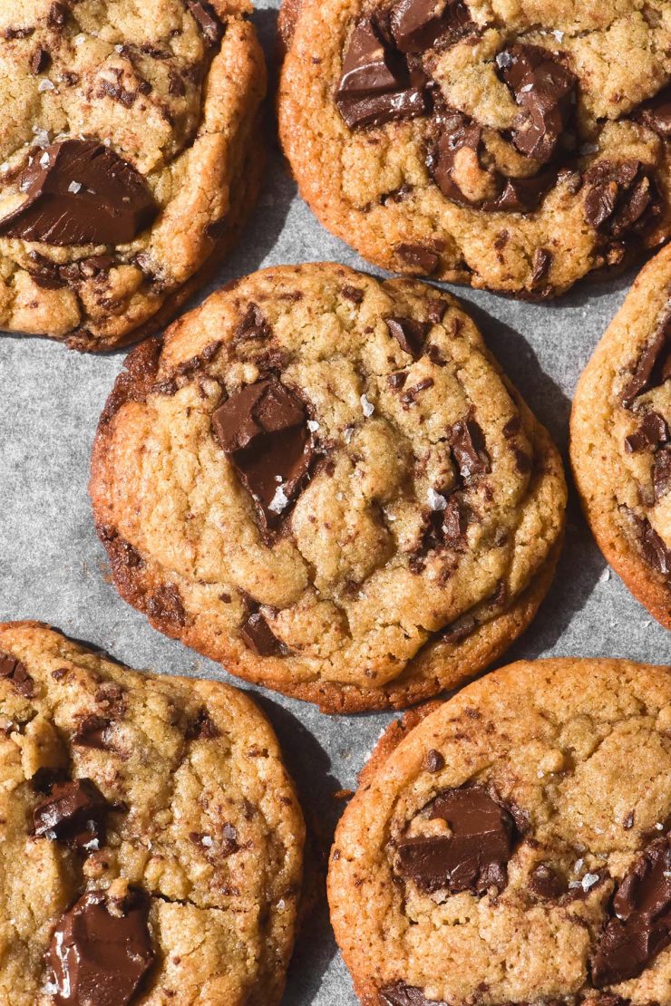 An aerial image of gluten free choc chip cookies on a lined baking tray