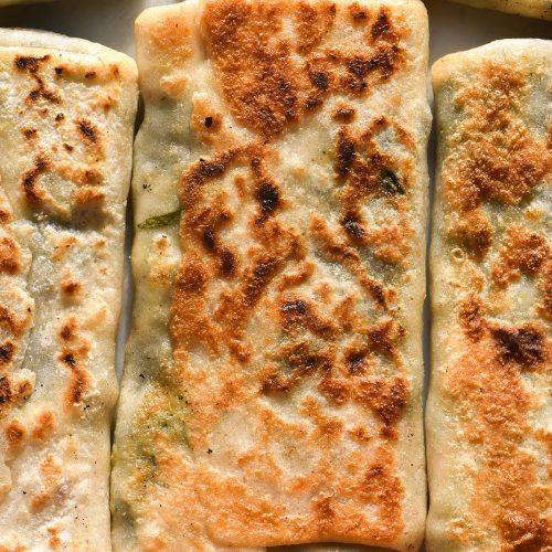 A macro aerial image of golden brown gluten free spinach and feta gozleme