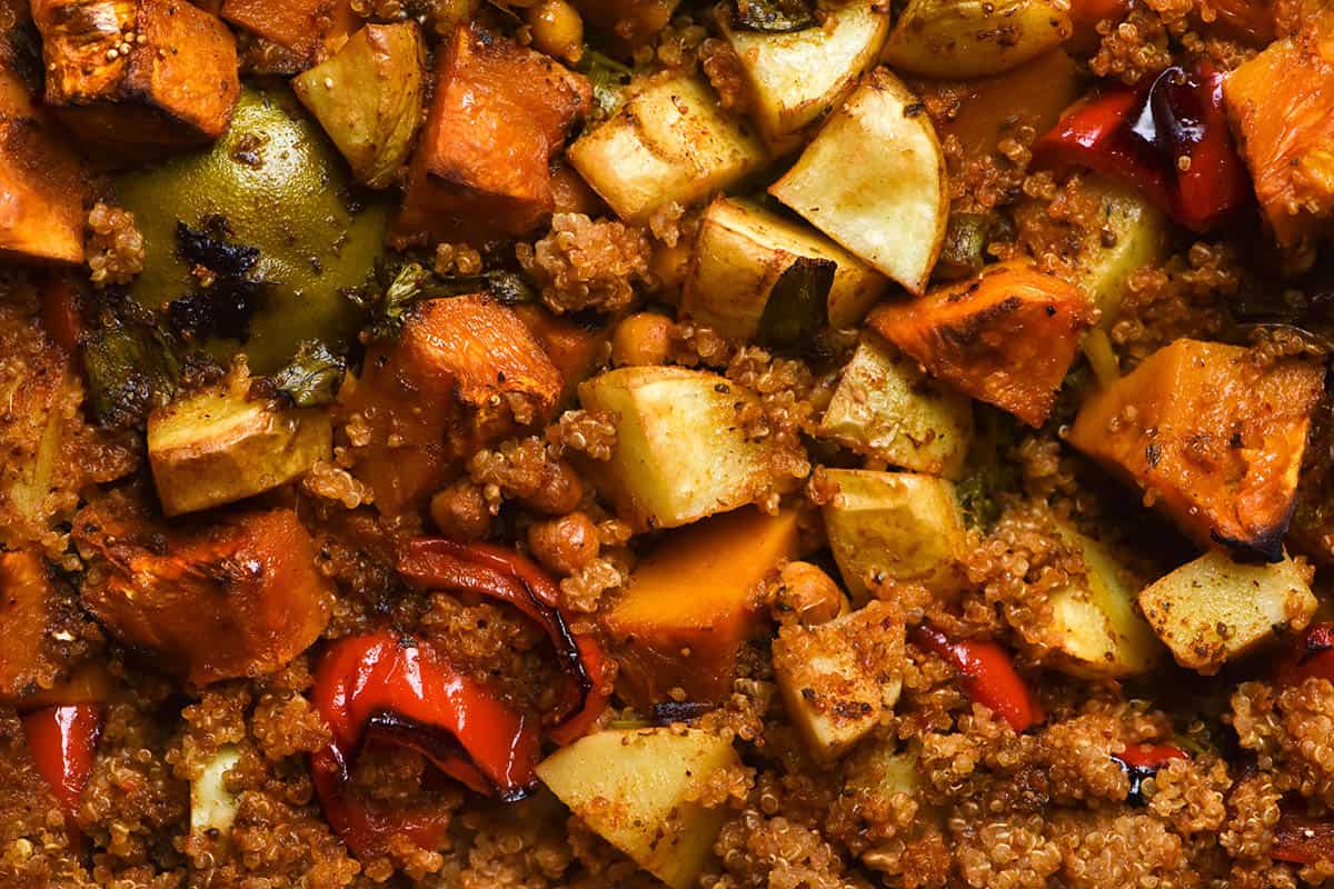 An aerial macro image of a quinoa, vegetable and chickpea bake with Mexican inspired spices and limes. 