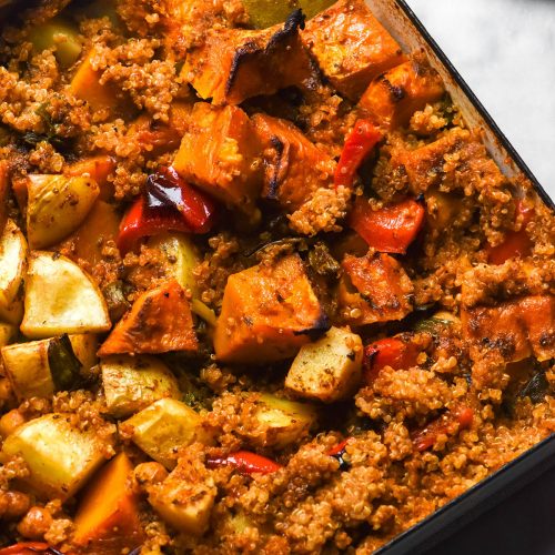 An aerial close up of a low FODMAP quinoa and vegetable bake on a white marble table