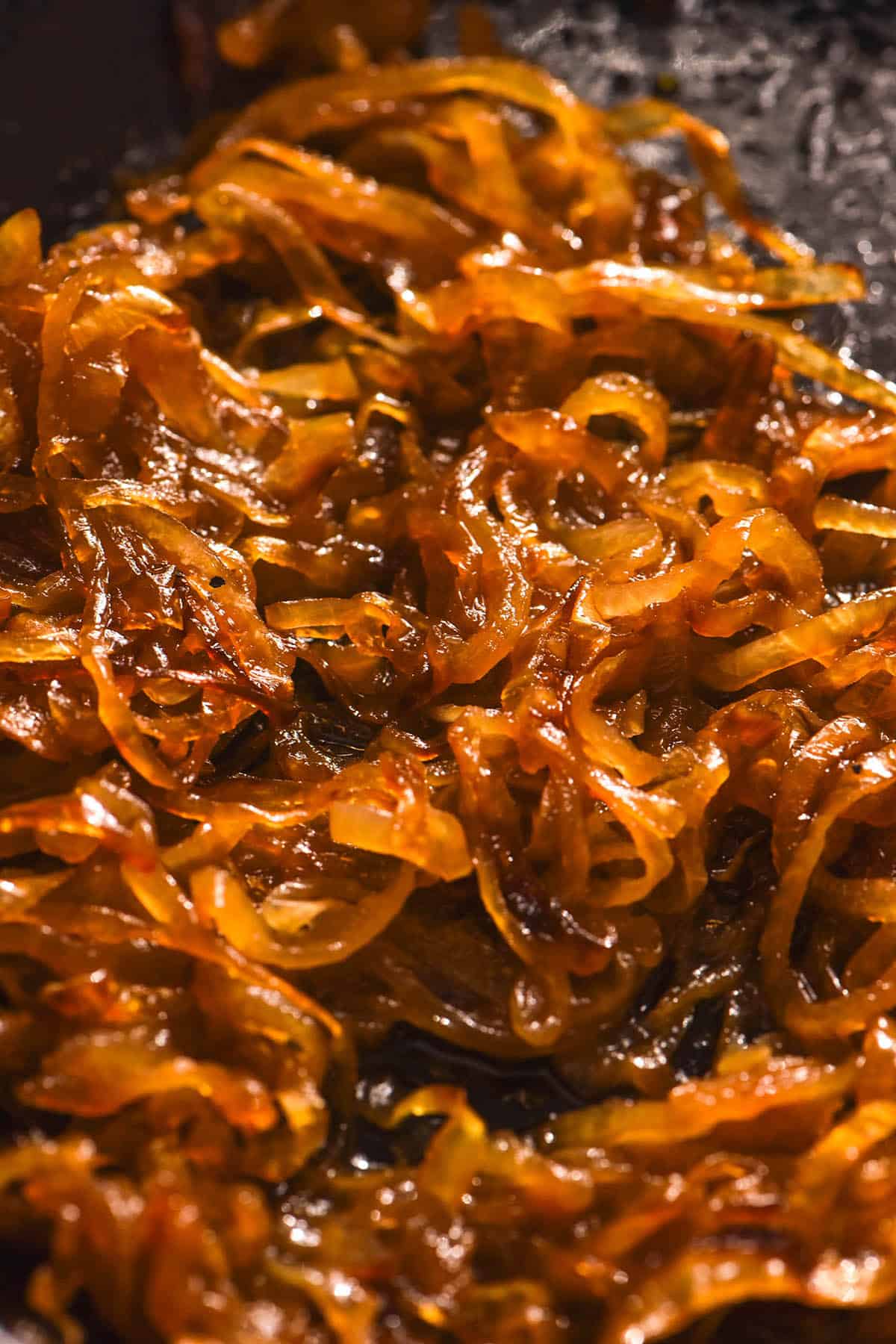 An aerial image of caramelised pickled onion in a black frypan