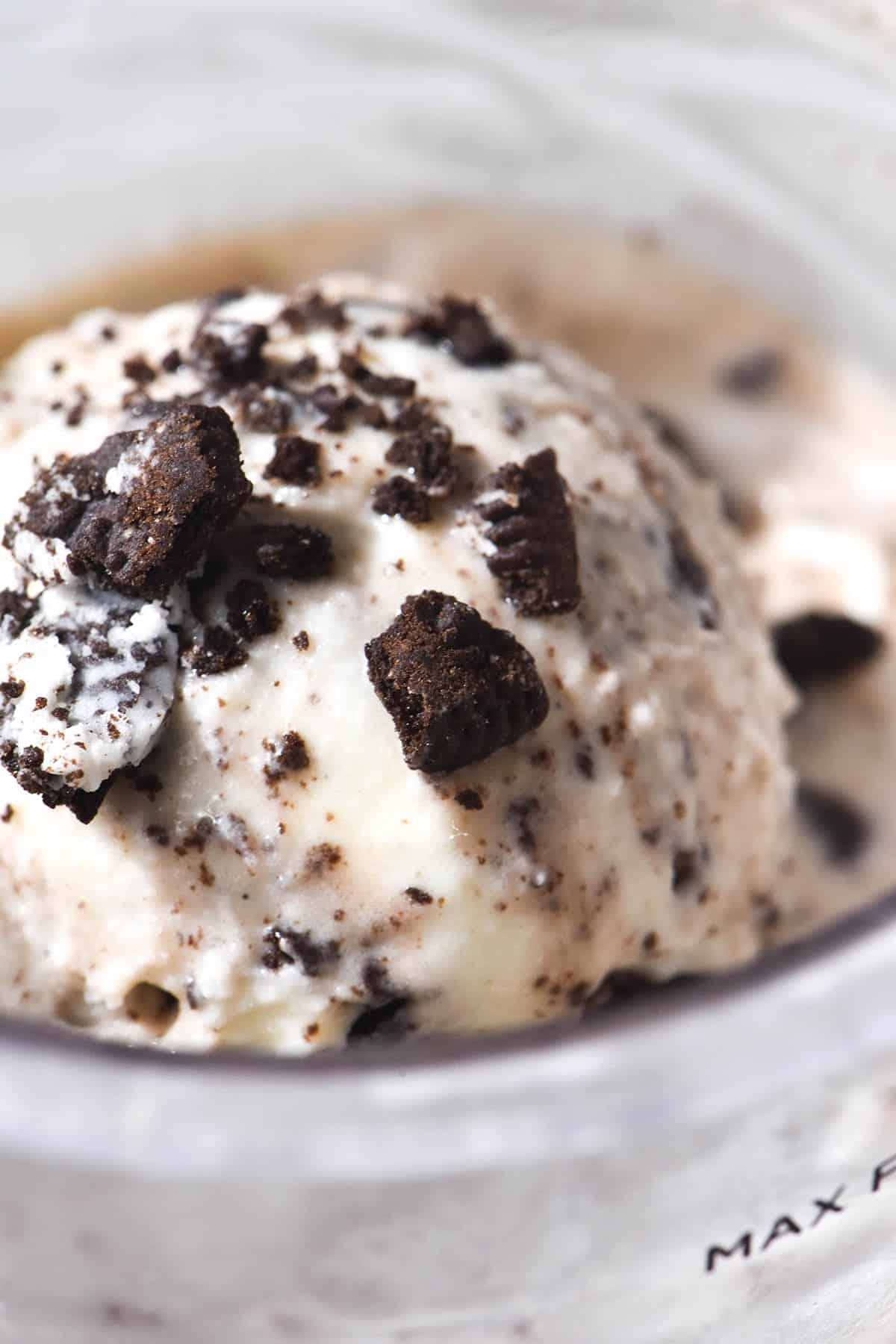 A macro close up of a scoop of Ninja Creami cookies and cream ice cream in the tub