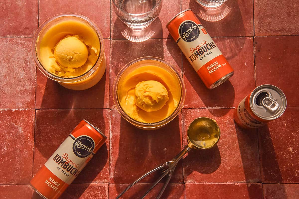 An aerial image of tubs of mango kombucha Ninja Creami on a terracotta tile backdrop