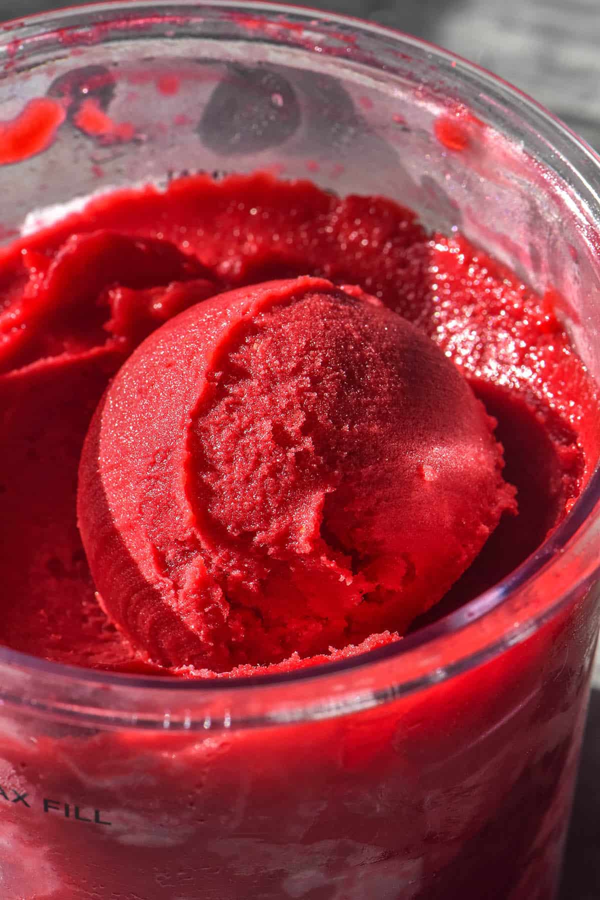 A close up aerial image of a scoop of Ninja Creami raspberry sorbet 