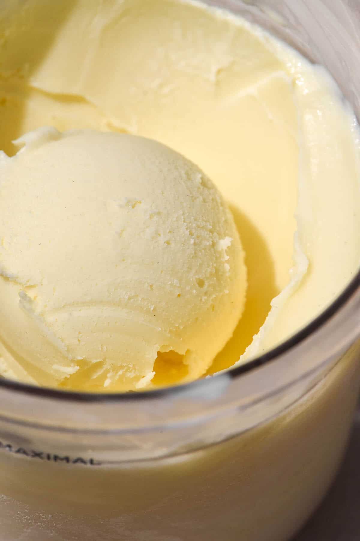 A close up macro image of a scoop of vegan vanilla ice cream in a Ninja Creami tub