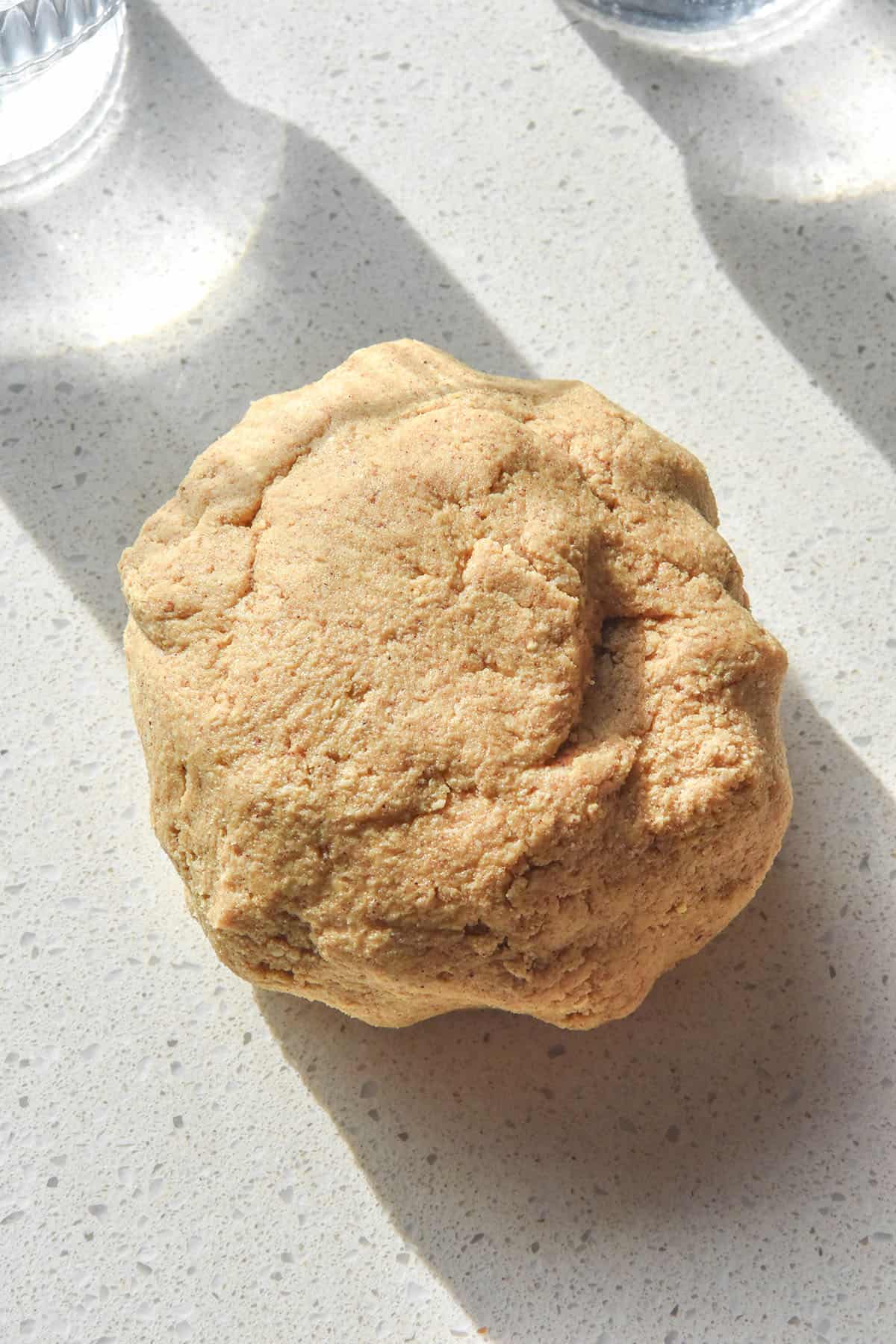 A sunlit aerial image of a ball of gluten free digestive biscuit dough to demonstrate the consistency that the dough needs to be