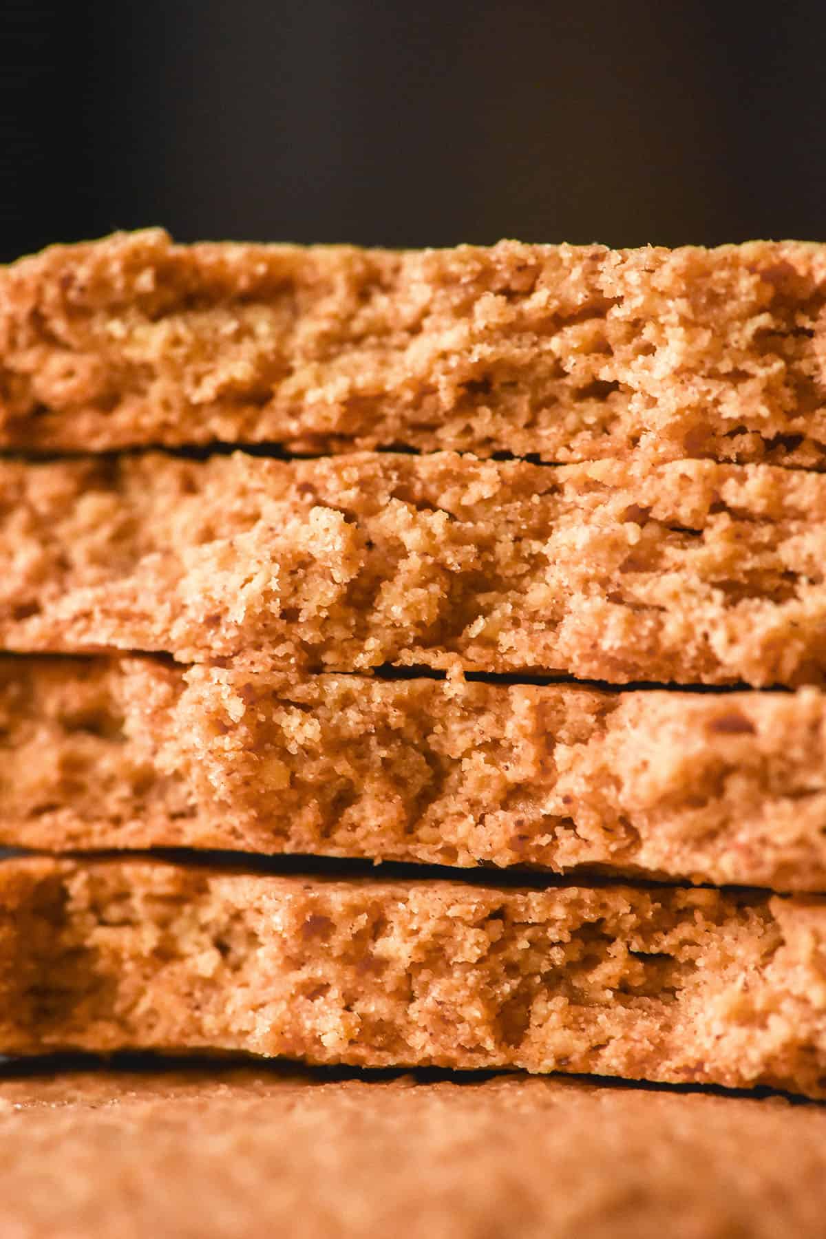 A close up macro image of a stack of gluten free digestive biscuits that have been snapped in half, revealing the crumb of the biscuit