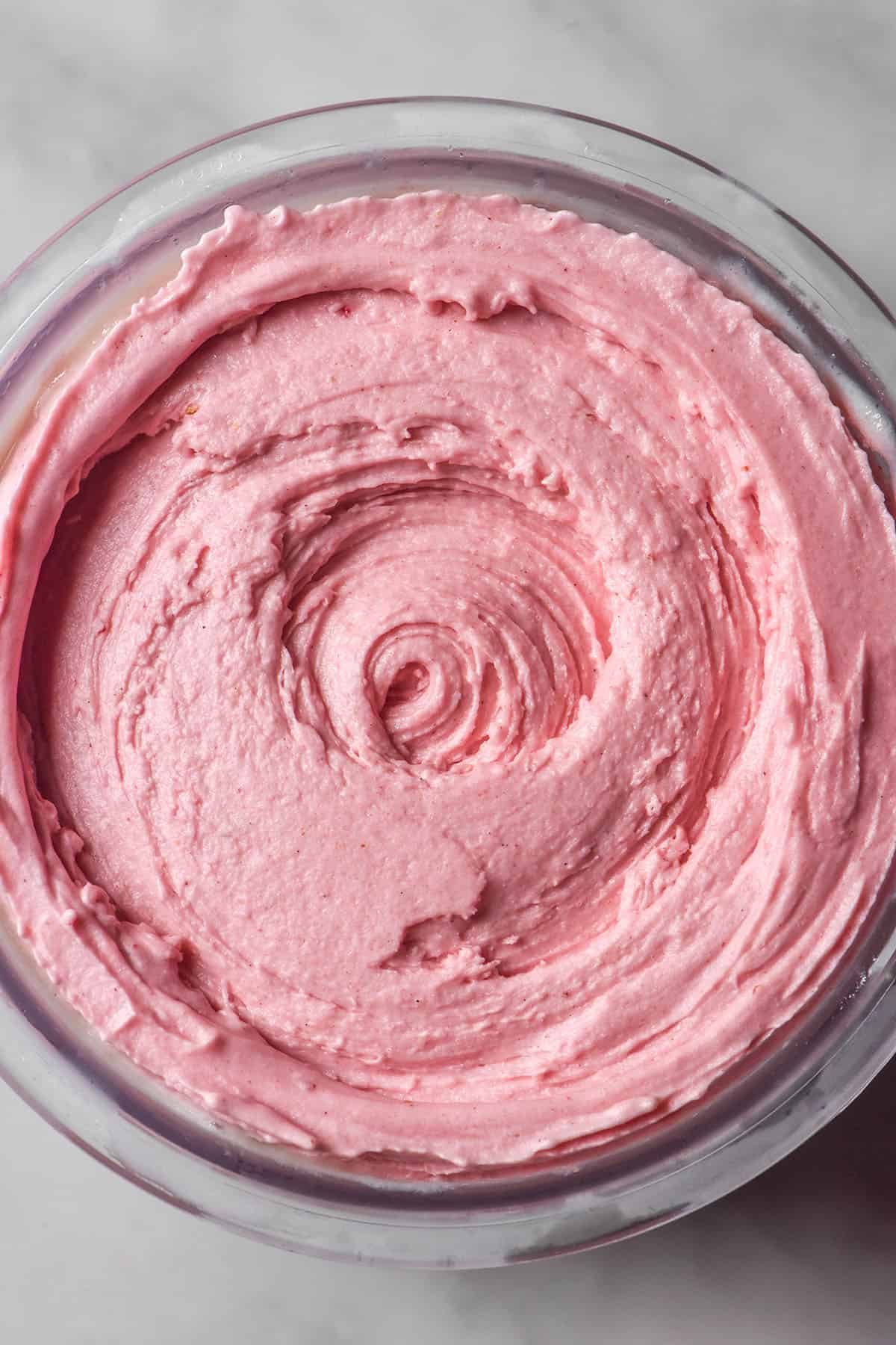 A brightly lit aerial image of a tub of high protein strawberry Ninja Creami ice cream 