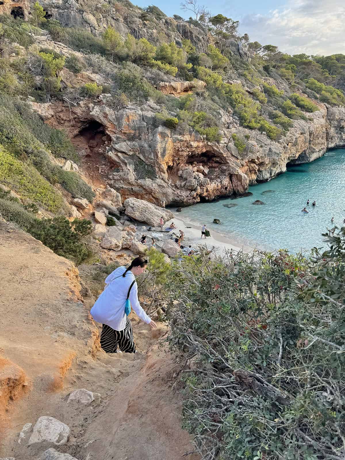 An image of Calo Des Moro and the rock scramble required to reach the beach from the cliffs