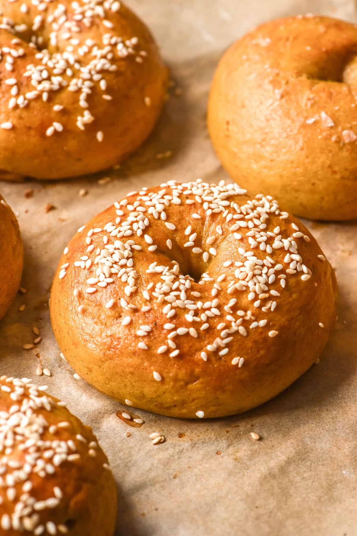 An image of gluten free pumpkin bagels topped with sesame seeds on a baking tray