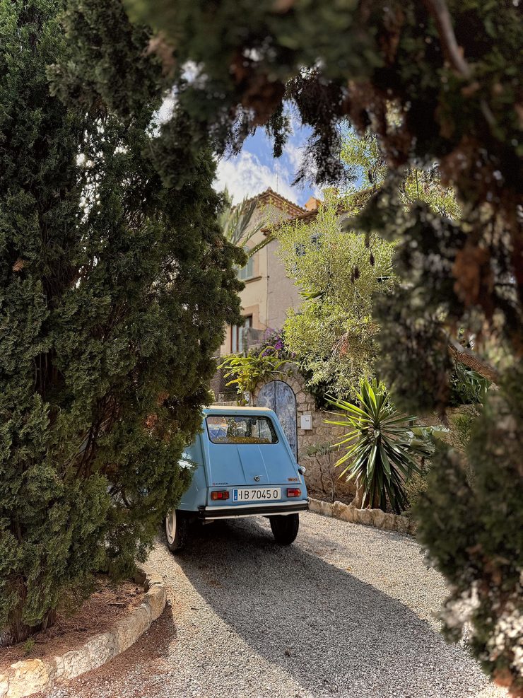 An image of an old car in a driveway at the top of the Calvari steps in Mallorca, Spain