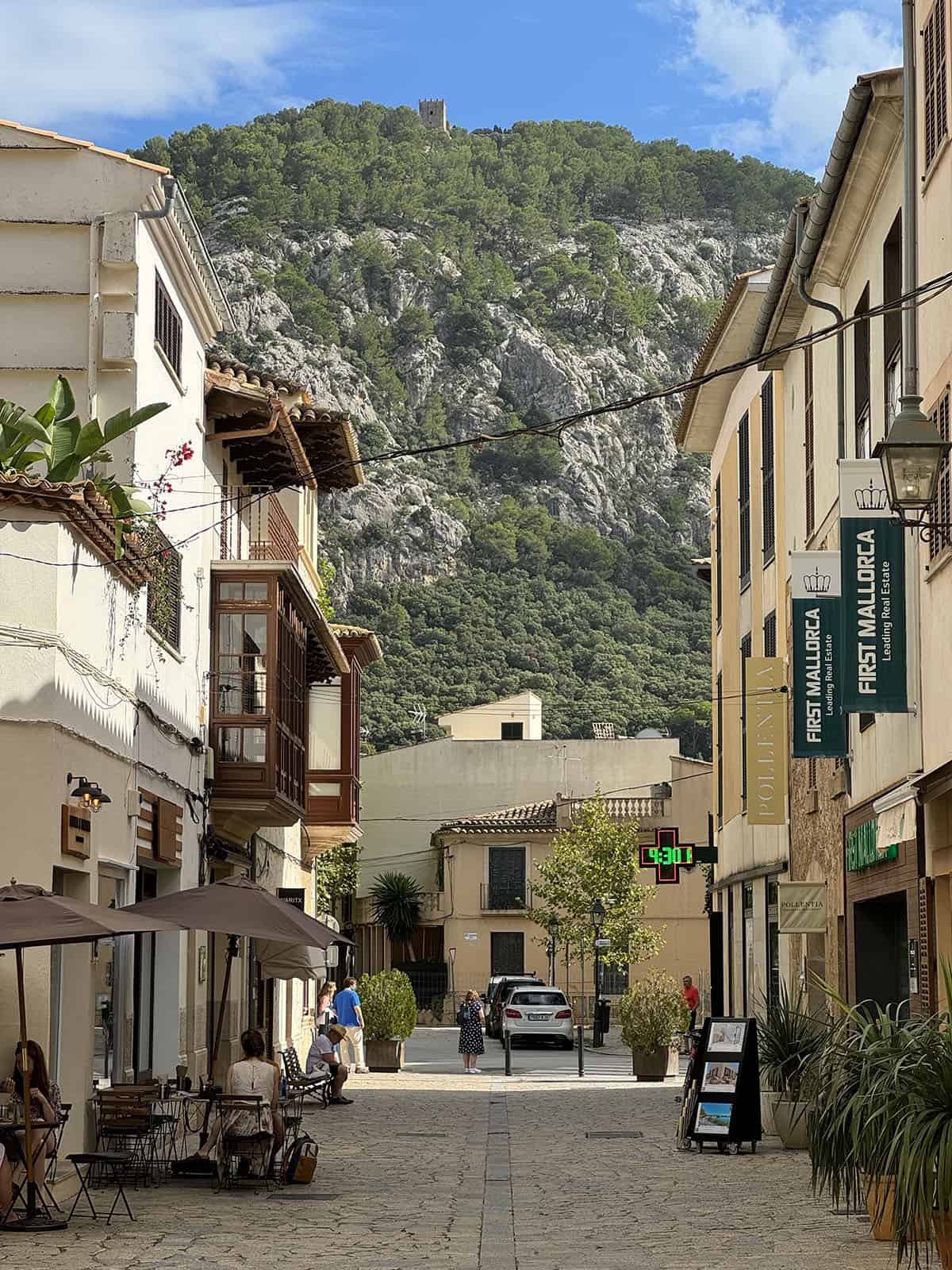 An image of Pollenca town set against the mountains and bright blue sky