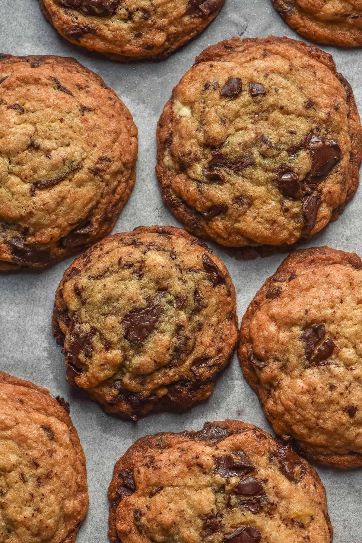 An aerial image of gluten free egg free banana choc chip cookies on a baking tray lined with white baking paper