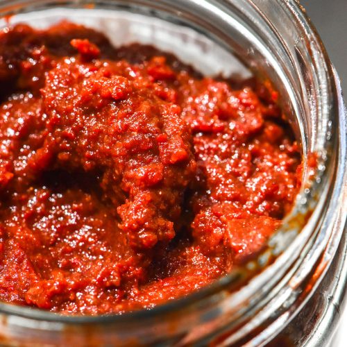 A close up macro image of a jar of gluten free gochujang