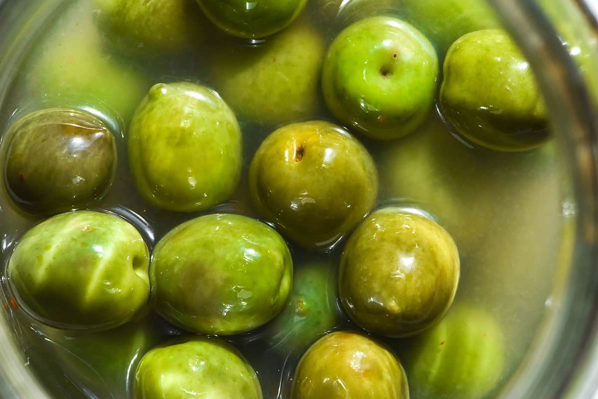 An aerial close up image of Italian margarita olives in a clear jar