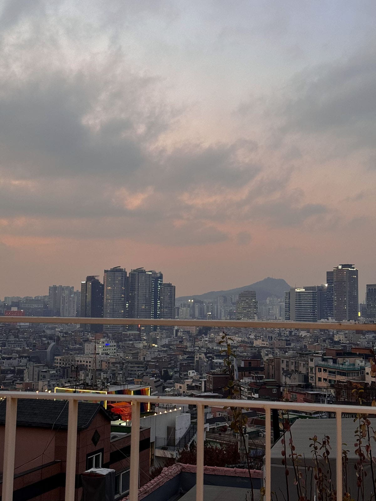 An image of a sunset over Seoul as viewed from a rooftop in Haebangchon