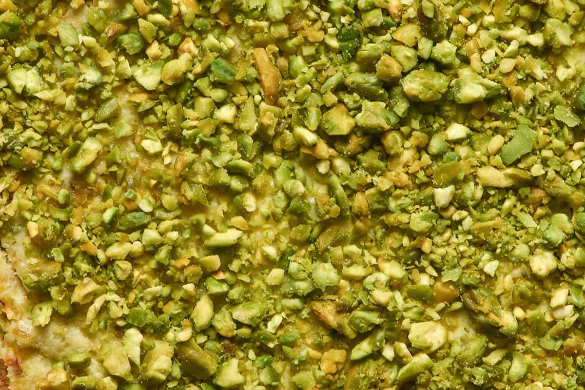 An aerial macro image of the chopped pistachios atop a gluten free pistachio Tiramisu